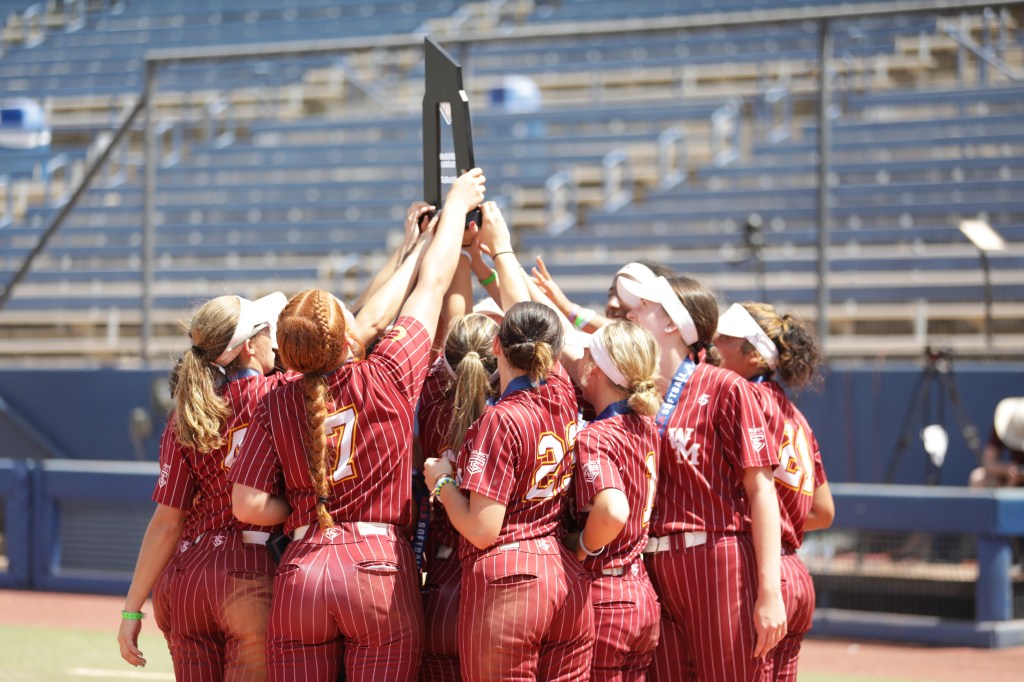 Girls Softball team posing with Trophy